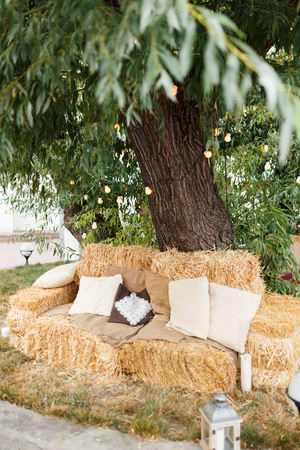 Christmas decorated place outside with lamps, linen pillows in haystacksの写真素材