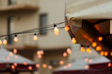 string wired with warming Light Bulbs hanging in the area of wedding events celebration in the nightの写真素材