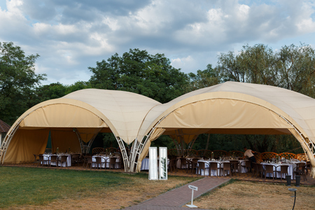 beautifully decorated wedding tent and wedding banquet on a background of skyの写真素材