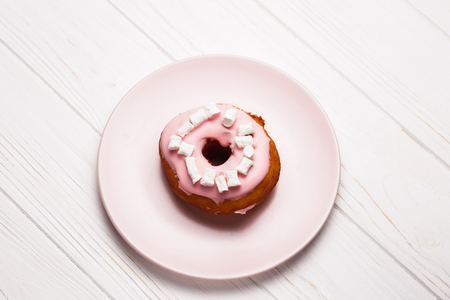 Pink donut with marshmallows on a Pink plateの写真素材