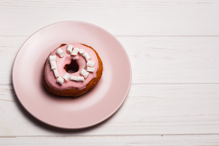 Pink donut with marshmallows on a Pink plateの写真素材