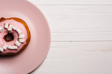 Pink donut with marshmallows on a Pink plateの写真素材