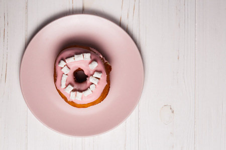 Pink donut with marshmallows on a Pink plateの写真素材
