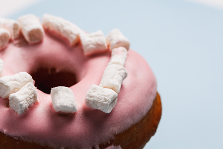 Pink donut with marshmallows on a blue backgroundの写真素材