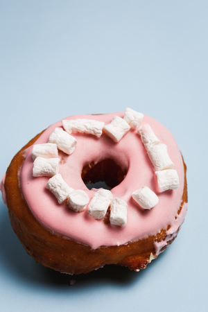 Pink donut with marshmallows on a blue backgroundの写真素材