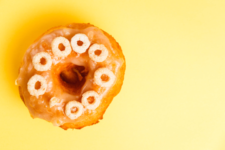 Donut with honey glaze on a yellow backgroundの写真素材