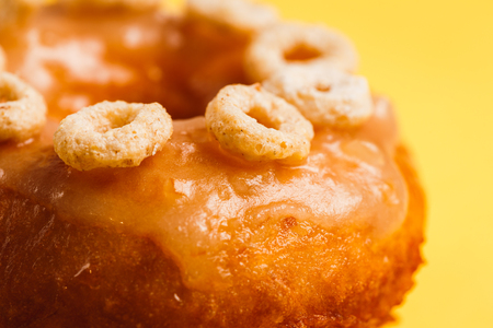 Donut with honey glaze on a yellow backgroundの写真素材