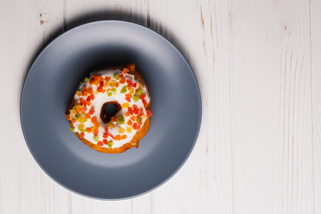fruit cake donuts in sweet glaze on a blue plateの写真素材