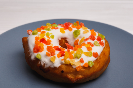 fruit cake donuts in sweet glaze on a blue plateの写真素材