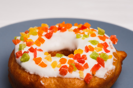 fruit cake donuts in sweet glaze on a blue plateの写真素材