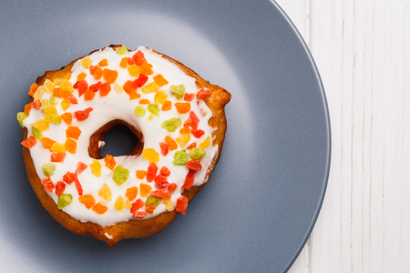 fruit cake donuts in sweet glaze on a blue plateの写真素材