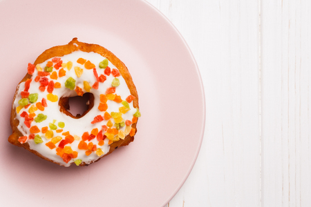 fruit cake donuts in sweet glaze on a pink plateの写真素材