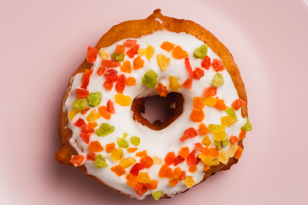 fruit cake donuts in sweet glaze on a pink plateの写真素材