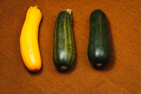 Fresh yellow and green zucchini on brown backgroundの写真素材