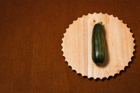 Fresh green zucchini on brown textile backgroundの写真素材