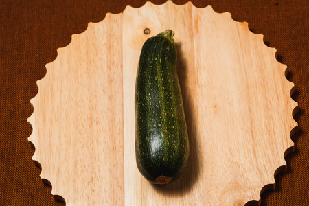Fresh green zucchini on brown textile backgroundの写真素材