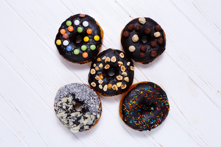 Delicious chocolate donuts with nuts over white backgroundの写真素材
