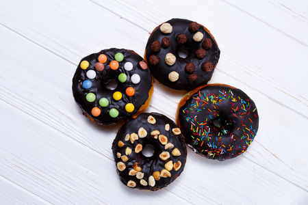 Delicious chocolate donuts with nuts over white backgroundの写真素材