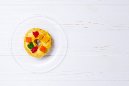 yellow donut in sugar glaze on a transparent plateの写真素材