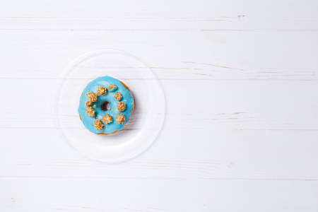 Blue donut in sugar glaze on a transparent plateの写真素材