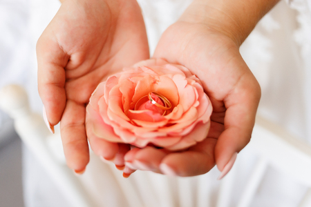wedding golden rings with pastel pink roseの写真素材