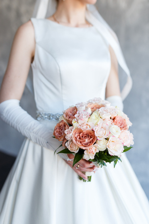Bride holding wedding bouquet of roses and beautiful flowersの写真素材