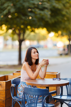 Beautiful Lady With A Coffee Sitting On A Summer Terraceの写真素材