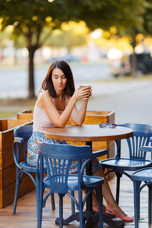 Beautiful Lady With A Coffee Sitting On A Summer Terraceの写真素材