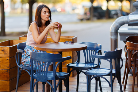 Beautiful Lady With A Coffee Sitting On A Summer Terraceの写真素材