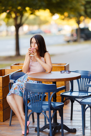 Beautiful Lady With A Coffee Sitting On A Summer Terraceの写真素材