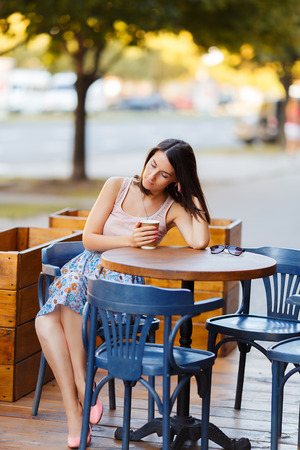Beautiful Lady With A Coffee Sitting On A Summer Terraceの写真素材