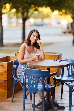 Beautiful Lady With A Coffee Sitting On A Summer Terraceの写真素材