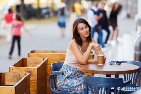 Beautiful Lady With A Coffee Sitting On A Summer Terraceの写真素材