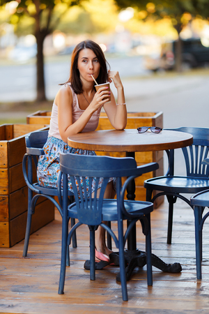 Beautiful Lady With A Coffee Sitting On A Summer Terraceの写真素材