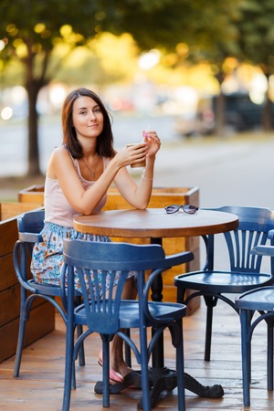 Beautiful Lady With A Coffee Sitting On A Summer Terraceの写真素材