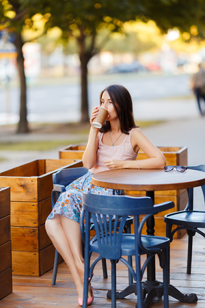 Beautiful Lady With A Coffee Sitting On A Summer Terraceの写真素材