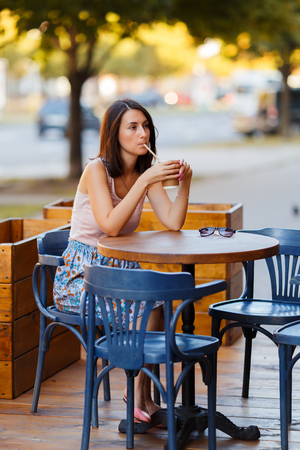Beautiful Lady With A Coffee Sitting On A Summer Terraceの写真素材