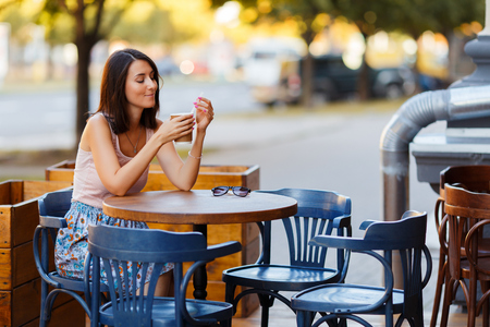Beautiful Lady With A Coffee Sitting On A Summer Terraceの写真素材