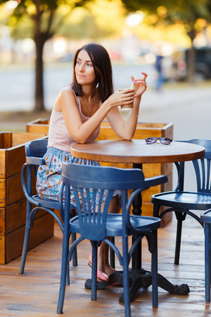 Beautiful Lady With A Coffee Sitting On A Summer Terraceの写真素材