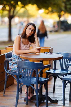 Beautiful Lady With A Coffee Sitting On A Summer Terraceの写真素材