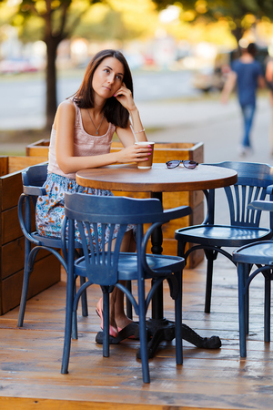 Beautiful Lady With A Coffee Sitting On A Summer Terraceの写真素材