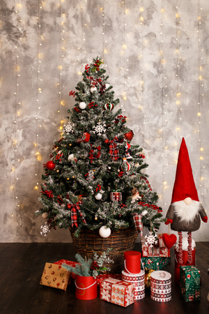 Cute winter gnome is waiting for christmas near the Christmas tree at home. Christmas time is near.の写真素材