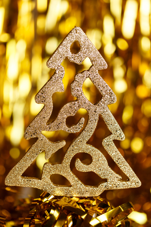 Golden Christmas tree on a gold backgroundの写真素材
