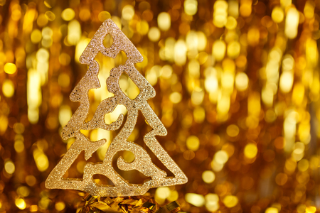 Golden Christmas tree on a gold backgroundの写真素材