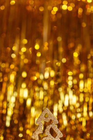Golden christmas tinsel tree decoration on glitter Golden