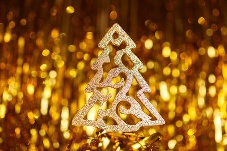 Golden Christmas tree on a gold backgroundの写真素材