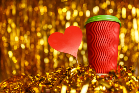 Christmas red cardboard cup of coffee with marshmallow on background with golden metafanの写真素材