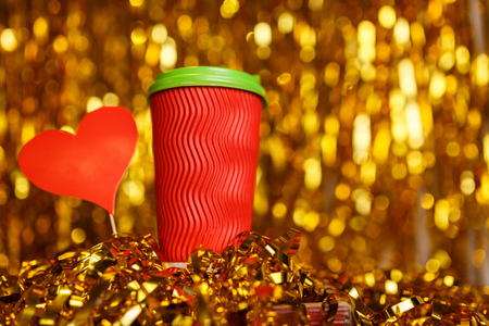 Christmas red cardboard cup of coffee with marshmallow on background with golden metafanの写真素材