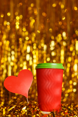 Christmas red cardboard cup of coffee with marshmallow on background with golden metafanの写真素材
