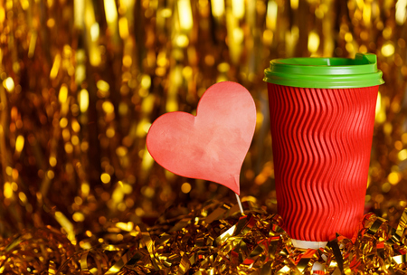 Christmas red cardboard cup of coffee with marshmallow on background with golden metafanの写真素材